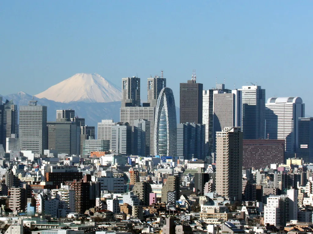 The Shinjuku skyline in Tokyo, with Mount Fuji on the horizon behind it.