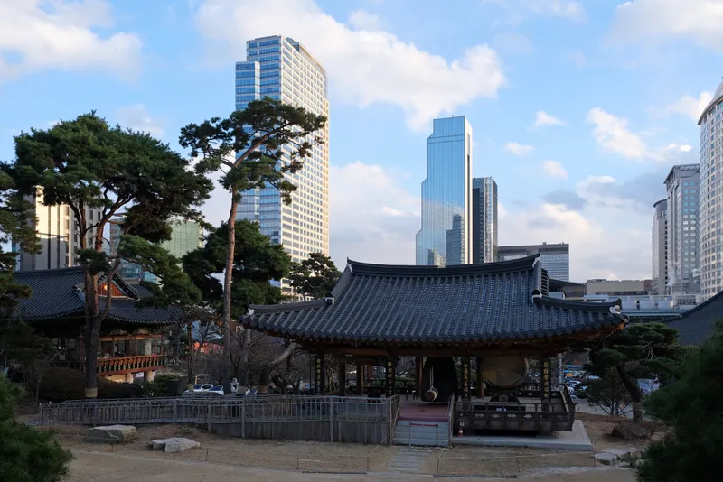 Temple halls at Bongeunsa with the towers of Gangnam rising behind them.