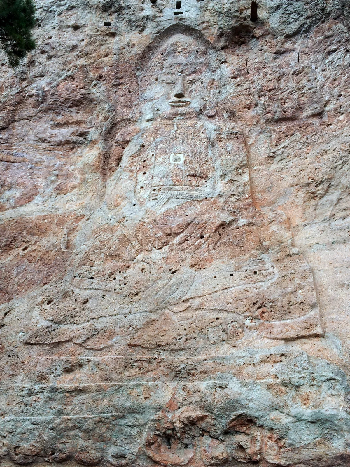 The rock-carved seated Buddha at the Dongbulam site beside Dosolam, cut into the cliff face.