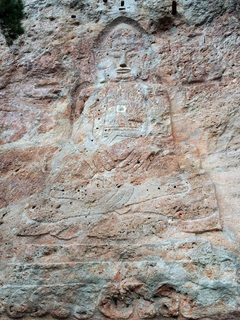 The rock-carved seated Buddha at the Dongbulam site beside Dosolam, cut into the cliff face.