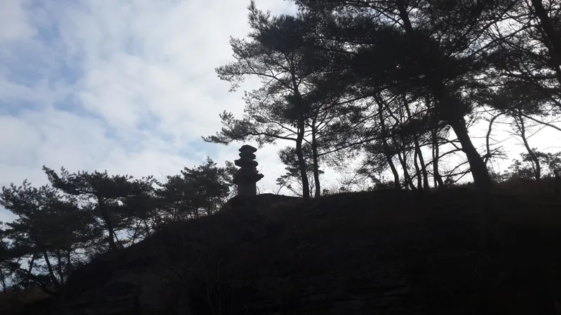 Stone pagodas and weathered stone buddhas scattered across the open valley floor at Unjusa.